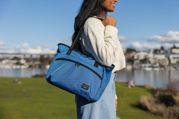A person carrying a Nomad Tote on their shoulder.